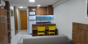 a kitchen with two yellow chairs and a counter at WEST FLAT MOSSORÓ in Mossoró