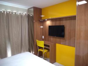 a bedroom with a bed and a tv on a wall at WEST FLAT MOSSORÓ in Mossoró