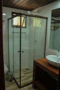 a bathroom with a glass shower and a sink at Complexo de Pousadas Caraguatá in Ilha do Mel +45 photos