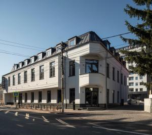 a white building on the corner of a street at Atlas Aparthotel & Spa in Piatra Neamţ
