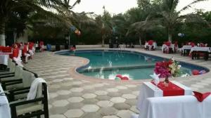 a swimming pool with tables and chairs in a resort at Eco-Lodge Hotel Oasis Fishing in Saint-Louis