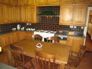 a kitchen with a wooden table and a stove at Ashleigh House - HOT TUB, Snooker table, Sleeps 24 in Henley in Arden