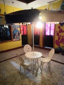 a table and four chairs in a room at Hostal Oaxaca Magic in Oaxaca City