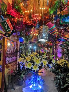 a room with a vase of yellow flowers and lights at Hostal Oaxaca Magic in Oaxaca City