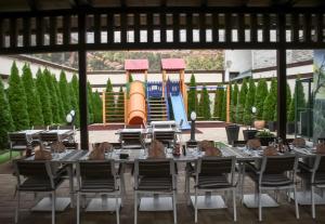 a long table and chairs with a playground in the background at Stari Slon in Sombor