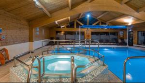 a large indoor swimming pool in a building at Fenna Lakeside Lodge - Pine Lake Resort in Carnforth