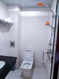 a white bathroom with a toilet and a sink at Xishuangbanna Aerial Garden Daijiangnan Mekong River South Business Hotel in Jinghong