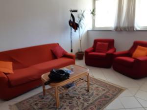 - un salon avec un canapé rouge et deux fauteuils rouges dans l'établissement FraSilvia, à Olbia