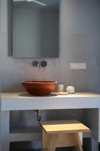 a bathroom sink with a wooden bowl on a counter at SifnosLiving A2 in Vathi
