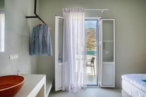 - une chambre avec une salle de bains pourvue d'une baignoire et d'un lit dans l'établissement SifnosLiving A2, à Vathi
