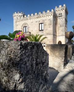 ein Gebäude mit einer Steinmauer mit Blumen darauf in der Unterkunft Rocca Giulia in Ostuni