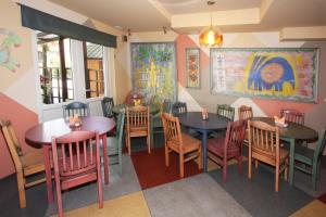 un restaurante con mesas y sillas y una pintura en la pared en Ema, en Palanga