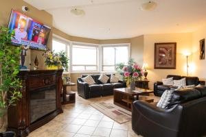 ein Wohnzimmer mit Sofas und einem Flachbild-TV in der Unterkunft Days Inn by Wyndham Bonnyville in Bonnyville