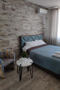 een slaapkamer met een bed, een tafel en een stoel bij Стильная квартира для отдыха и бизнес поездок in Kiev