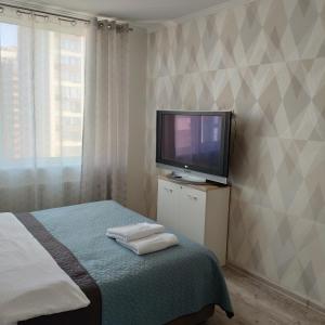 een slaapkamer met een tv en een bed met handdoeken bij Стильная квартира для отдыха и бизнес поездок in Kiev