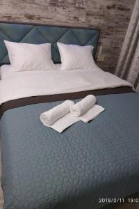 een bed met twee handdoeken en twee kussens erop bij Стильная квартира для отдыха и бизнес поездок in Kiev