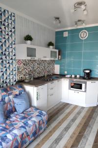 een keuken met witte kasten en een bank in een kamer bij Стильная квартира для отдыха и бизнес поездок in Kiev