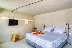 a bedroom with a bed with a tv on the wall at SifnosLiving A3 in Vathi