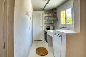 a kitchen with a sink and a white refrigerator at SifnosLiving A3 in Vathi