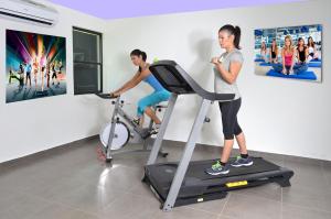 un hombre y una mujer en una cinta de correr en un gimnasio en 中国人之家公寓酒店Apart-Hotel Casa de China, en Managua