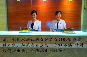 two women standing behind a table with writing on it at Xishuangbanna Aerial Garden Daijiangnan Mekong River South Business Hotel in Jinghong
