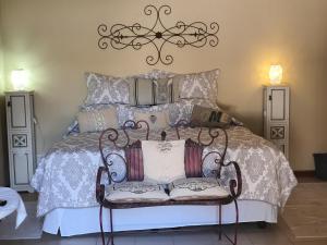 a bedroom with a bed with a wrought iron chair at Mia's in Tzaneen
