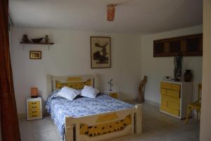 Schlafzimmer mit einem Bett mit blauer Decke in der Unterkunft Finca Jardín del Agua in Sasaima