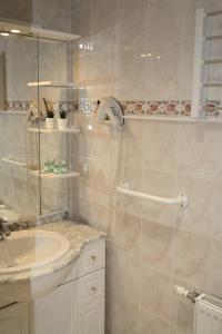 een witte badkamer met een wastafel en een douche bij La Ferme de la Place in Bouvines