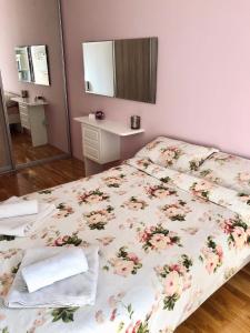 a bedroom with a bed with a floral bedspread at Modern Cosy Apartment by SMM in Skopje
