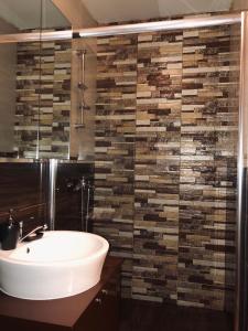 a bathroom with a sink and a tile wall at Modern Cosy Apartment by SMM in Skopje +3 photos