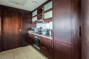 a kitchen with wooden cabinets and a counter top at Frank Porter - The Residences in Dubai
