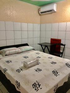 a bedroom with a bed and a table with chairs at Hotel Fortaleza III Manaus in Manaus