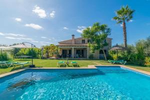 a swimming pool in front of a house at Mercader in Alcudia