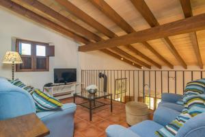 a living room with blue couches and a tv at Mercader in Alcudia