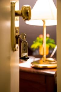 einem Türverschluss mit einem Schlüssel vor einer Lampe in der Unterkunft Lion's Hotel in Falerna