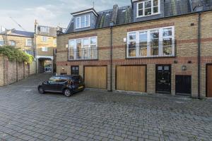 a car parked in front of a brick building at Lovely 2bed house in Wandsworth w/ backyard patio in London