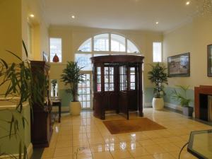 a lobby with a wooden door and plants in it at Burlington Mansions in Bournemouth