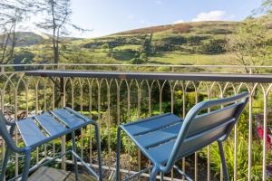 uma mesa e cadeiras numa varanda com vista para as colinas em St Marks Stays em Sedbergh