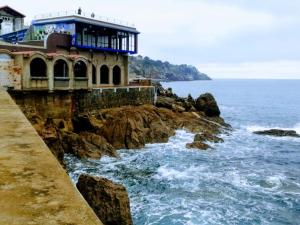 a building on a cliff next to the ocean at Euskal Dreams Apartment in Bermeo