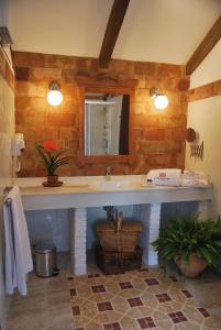 un baño con lavabo y espejo en Hotel Rural Casa Grande Almagro, en Almagro 35 fotos más
