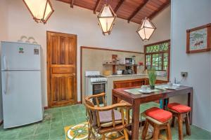 a kitchen with a table and a refrigerator at Villa 4 - Amazing 2 Bed Villa with Private Garden, Playa Chiquita in Cocles