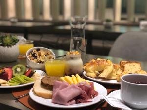 a table with plates of breakfast foods and drinks at Huinid Obelisco Hotel in Buenos Aires