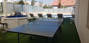 two ping pong tables and chairs on an apartment patio at וילה סאן אילת in Eilat