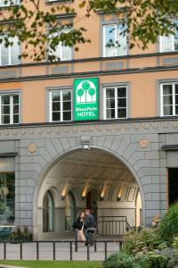 a woman walking down a street next to a building at Wasa Park Hotel in Stockholm