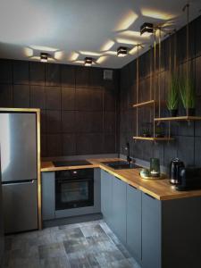 een keuken met een wastafel en een koelkast bij Apartament Skandynawski Sienkiewicza 13 in Kielce