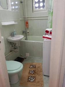 a bathroom with a sink and a toilet and a bath tub at Sara Apartman in Târgu-Mureş
