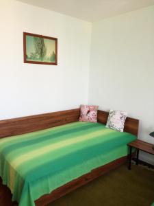 a bedroom with a bed with a colorful blanket at Sara Apartman in Târgu-Mureş