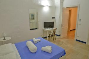 カンピ・サレンティーナにあるFenisia Guest House option wellnessの青いベッド1台(枕2つ付)が備わる客室です。