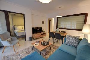 uma sala de estar com um sofá azul e uma mesa em Onar Modern Luxury Apartments em Cavala