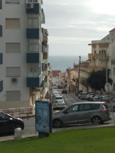 a street with cars parked on the side of a building at Apartamento Blue dream in Sesimbra